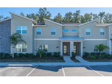 Modern two-story townhome with gray siding and landscaping at 2381 Reading Trl, Kissimmee, FL 34746