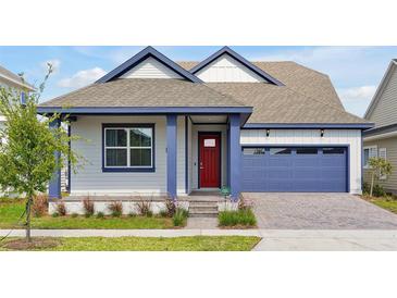 Two-story Craftsman home with red door, blue garage, and landscaped yard at 3055 Prospect Trl, St Cloud, FL 34771