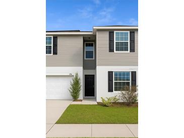 Charming two-story home featuring a well-manicured lawn and attached garage at 196 Albany Dr, Kissimmee, FL 34759