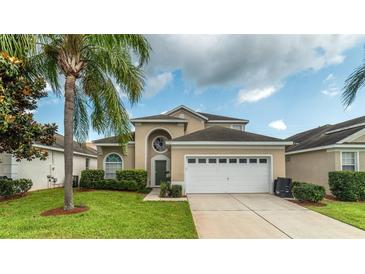 Attractive two-story house with a two-car garage and lush landscaping at 2243 Wyndham Palms Way, Kissimmee, FL 34747