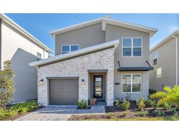 Modern two-story home features a stone facade, gray siding, and a one-car garage at 2797 Bookmark Dr, Kissimmee, FL 34746