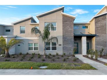 Modern two-story townhome with stone accents and landscaped front yard at 4349 Quote St, Kissimmee, FL 34746
