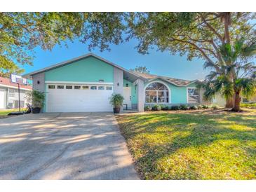 Charming light teal house with a white garage door and manicured lawn at 1188 Anne Elisa Cir, St Cloud, FL 34772