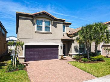 Two-story house with a brown garage door and landscaped yard at 1610 Lima Ave, Kissimmee, FL 34747