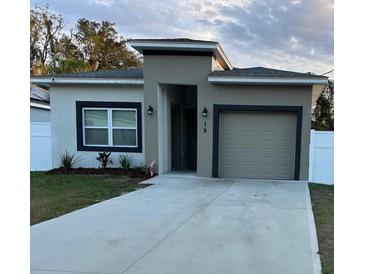 Attractive exterior with a one-car garage, manicured lawn, and modern color scheme at 19 James Ct, Davenport, FL 33837