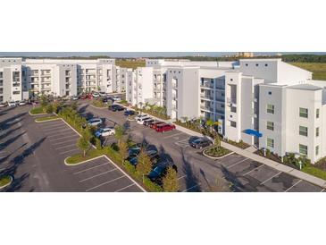 Aerial view of apartment building with parking and surrounding landscape at 4731 Clock Tower Dr # 206, Kissimmee, FL 34746