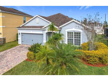 Charming single-Gathering home boasts a well-manicured lawn and an attached two-car garage at 1404 Lexington Avenue, Davenport, FL 33837