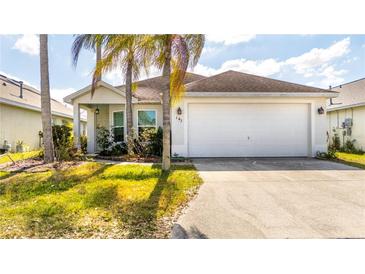 Charming single-story home with well-maintained landscaping and a two-car garage at 143 Hollingshead Loop, Davenport, FL 33896