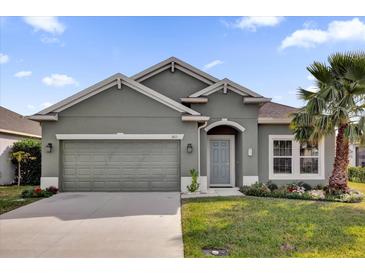 Single-story house with gray exterior, two-car garage, and landscaped lawn at 1813 Castleton Dr, St Cloud, FL 34771