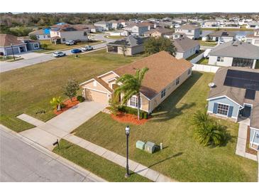 Single-Gathering home with a landscaped yard, driveway, and palm trees at 2542 Bobby Lee Ln, St Cloud, FL 34772