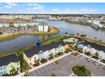 Aerial view of a townhome community with lake access and a community pool at 3065 Caribbean Soul Dr, Kissimmee, FL 34747