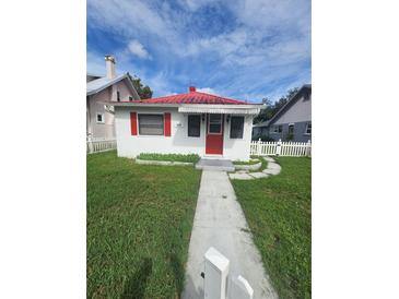 Charming home with a red roof, red door, and a well-manicured front yard at 433 Pennsylvania Ave, St Cloud, FL 34769