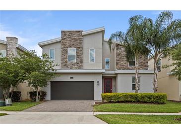 Two-story modern home with stone accents and landscaped yard at 641 Pebble Beach Dr, Davenport, FL 33896