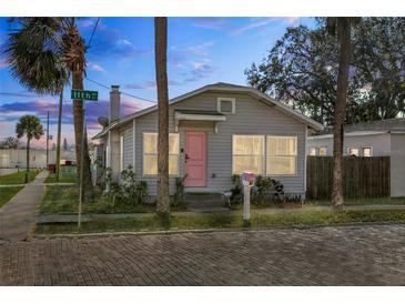 Cute bungalow with pink door, gray siding, and brick pavers at 1001 11Th St, St Cloud, FL 34769