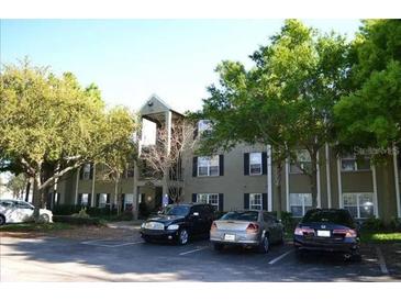 Exterior view of a multi-story apartment building with mature trees and visible parking at 2007 Dixie Belle Dr # 2007 I, Orlando, FL 32812