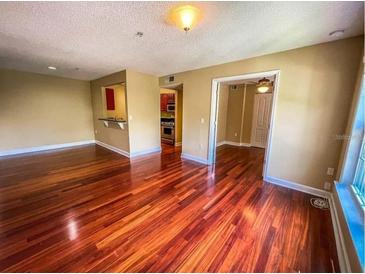 Bright living room with hardwood floors and view into kitchen at 2007 Dixie Belle Dr # 2007 I, Orlando, FL 32812