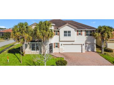 Two-story house with a two-car garage, and a nicely landscaped lawn at 2821 Rialto Ct, Kissimmee, FL 34746