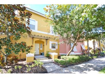 Inviting exterior of two-story townhome with landscaping and walkway at 4748 Vero Beach Pl, Kissimmee, FL 34746