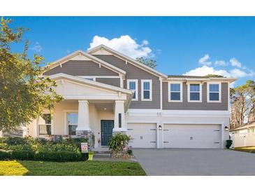 Two-story home with gray siding, white trim, and a three-car garage at 11120 Robert Frost Dr, Winter Garden, FL 34787