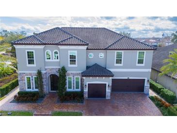 Two-story house with gray exterior, brown roof, and a two-car garage at 16548 Raven Rock Pl, Winter Garden, FL 34787