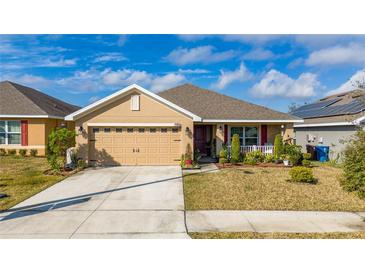Charming single Gathering home featuring a two-car garage and landscaped front yard with a well-manicured lawn at 264 Citrus Pointe Dr, Haines City, FL 33844
