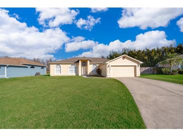 Beautiful yellow house with a large yard and driveway at 2715 Rismen Ct, Kissimmee, FL 34743
