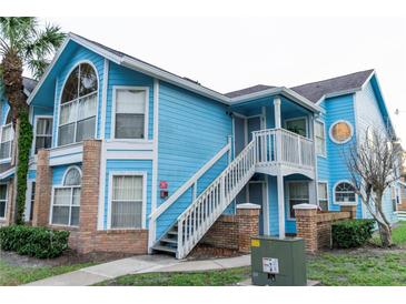 Light blue two-story condo building with brick accents and a stairway at 2741 N Poinciana Blvd # 43, Kissimmee, FL 34746