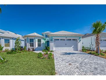 Charming single-Gathering home boasting a manicured lawn and brick paved driveway at 306 Hang Loose Way, Daytona Beach, FL 32124