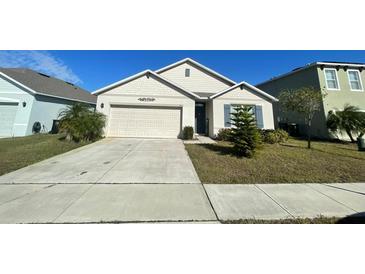 Well-maintained house with a two-car garage and manicured lawn at 3181 Serendipity Way, Davenport, FL 33896