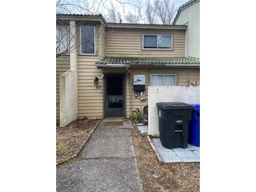 Tan exterior condo with a walkway, landscaping, and solar panels at 428 Sand Lime Rd, Winter Garden, FL 34787