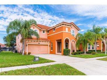 Two-story house with orange stucco and a tile roof, featuring palm trees and a landscaped yard at 4525 Stella St, Kissimmee, FL 34746