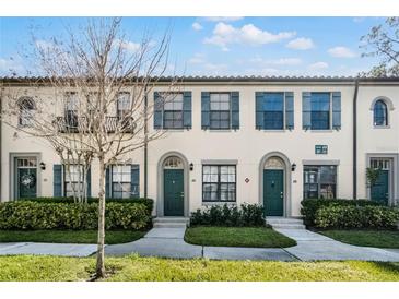 Front view of charming townhouses with green doors and landscaping at 709 Centervale Dr, Celebration, FL 34747
