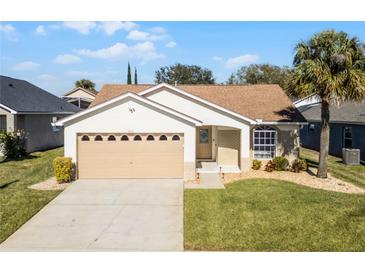 One-story home with beige exterior, attached garage, and landscaped lawn at 7833 Turkey Oak Ln, Kissimmee, FL 34747