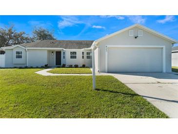 Charming single-story home with a well-maintained lawn and attached two car garage at 827 Albi Ct, Kissimmee, FL 34759