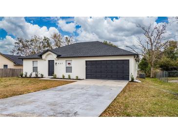 Newly constructed home with a gray roof, white exterior, and a dark gray garage door at 937 Elkcam Blvd, Deltona, FL 32725