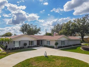 Charming one-story home featuring a circular driveway, lush landscaping, and a well-maintained lawn at 123 Lakeview Dr, Auburndale, FL 33823