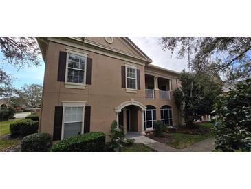 Charming home showcasing a two-story design, complemented by a quaint balcony and meticulously maintained landscaping at 14214 Fredricksburg Dr # 106, Orlando, FL 32837
