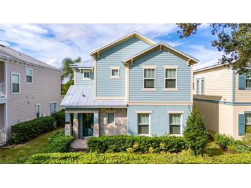 Two-story house with light blue siding, stone accents, and a landscaped front yard at 1432 Reunion Blvd, Reunion, FL 34747