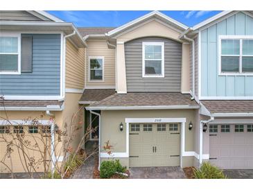Two-story townhome with light-grey and blue siding, and a two-car garage at 2559 Sedge Grass Way, Orlando, FL 32824