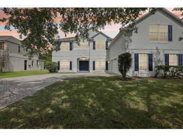 Charming two-story home with a brick driveway, well-manicured lawn, and white stucco exterior at 3209 Eagle Watch Dr, Kissimmee, FL 34746