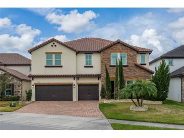 Two-story house with stone accents and a two-car garage at 3240 Preserve Dr, Orlando, FL 32824