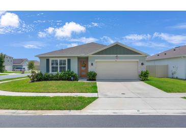 Charming single-story home with a well-manicured lawn and a two-car garage on a sunny day at 401 Chayne Pl, St Cloud, FL 34771
