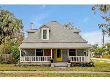 Charming two-story home featuring a cozy front porch, bright yellow door, and beautifully landscaped front yard at 723 New York Ave, St Cloud, FL 34769