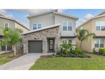 Two-story home with stone accents and a two-car garage at 771 Drop Shot Dr, Davenport, FL 33896