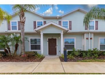 Charming two-story home with tropical landscaping, inviting entrance, and attractive architectural details at 8919 Shine Dr, Kissimmee, FL 34747
