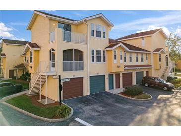 Exterior view of a two-story condo building with attached garages and balconies at 12209 Wild Iris Way # 110, Orlando, FL 32837