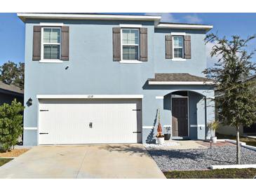 Two-story house with white garage door and gray siding at 1239 Berry Ln, Davenport, FL 33837