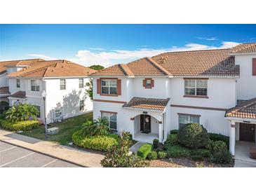 Charming two-story home featuring a red tile roof, stucco walls, and a well-manicured front yard at 1596 Moon Valley Dr, Davenport, FL 33896