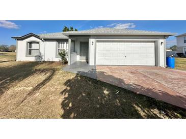 Charming single-story home with attached two-car garage and well-maintained lawn at 1921 Drum Dr, Kissimmee, FL 34759