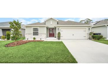 Charming single-story home boasts a well-manicured lawn, tidy landscaping, and a two-car garage at 1944 Harvest Landing Cir, Lakeland, FL 33810